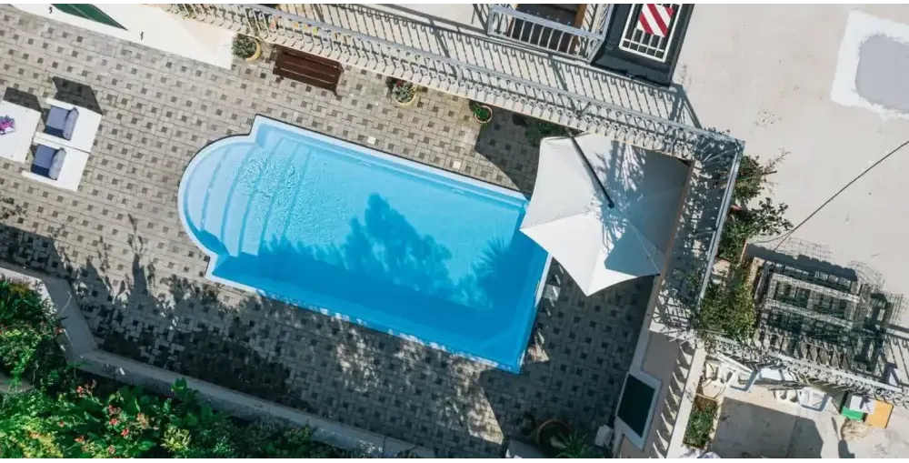 Glasfiberpool Aves med avrundad trappa och kaklad omgivning